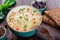 Rice with vegetables, peas, carrots, peppers on plate on wooden background.