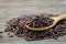 Riceberry in wooden spoon on rustic wood background.