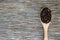 Riceberry in wooden spoon on rustic wood background.