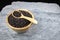 Riceberry and wooden spoon in a wooden cup placed on stone slabs