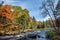 Rich colors of an autumn forest on a stony riverside