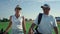Rich couple talking golf sport outside. Two country club members walk on fairway