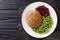 Rich and delicious Swedish veal patties Wallenbergare with boiled green peas closeup in the plate. Horizontal top view