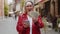 Rich elderly woman counting money dollar cash, use smartphone calculator app in urban city street