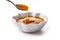 rich and indulgent caramel sauce sits thick and sticky in a small ceramic bowl, tempting those with