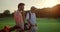 Rich men playing golf on sunset summer course. Two players enjoy sport on field.