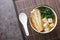 Rich miso soup with enoki mushrooms, wakame seaweed and tofu, vegetarian, vegan Asian food close-up in a bowl. Horizontal top view