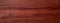 Rich Textured Red Walnut Wood Surface Close-up. Detailed view of red walnut wood showing the natural grain and warm