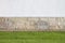 Rich white wall, horizontal rectangular stones and a green lawn