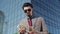 Rich Young Bussinessman in Suit Wearing Sunglasses Counting Money near Skyscrapper