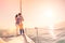 Rich young couple in love on sailboat cheering at sunset