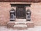 Richly carved dark wood door in the traditional Nepali style with two beautiful life-size statues