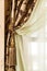 Richly decorated curtain with a holding strap