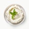 ricotta cheese in a white saucer with a mint leaf