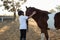 Rider boy caressing a horse in the ranch