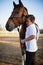 Rider boy caressing a horse in the ranch