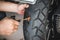 Rider use a tire plug kit and trying to fix a hole in tire`s sidewall ,Repair a motorcycle flat tire in the garage. motorcycle