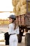 Rider woman in helmet stands near stables