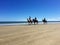 Riders on horseback on 90 Mile Beach, Ahipara, New Zealand