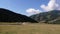 Riders on horses in field with Tian Shan mountains in Kyrgyzstan