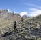 Riders on horses with weapons climb the mountain slope