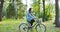 Riding a bike in park, cycling during quarantine. Girl in mask drives bicycle.