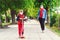 Riding boy on scooter in park. Boy wears medical face mask. Mother and son on a walk during coornavirus quarantine