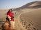 Riding a Camel in A Part of Silk Road in Dunhuang Desert. Travel