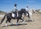 Riding couple on the beach