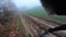 Riding a mountain bike on a muddy gravel path on a green foggy landscape