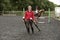 Riding school pupil and instructor with poles for a jump