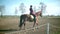 Riding school. Young handsome woman rides a horse slow motion 4K