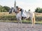 Riding white Lusitano horse, outdoors, cute team, riding arena outside