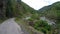 Riding on winding mountain road along fast-streamed river and steep cliffs