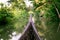 Riding wood fishing boat in kerala backwaters village water channel under palm trees, a pristine natural environment during