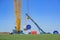 Rieps, Germany, April 22, 2023: Part of a tubular steel tower for a wind turbine power plant is moved by two cranes on the