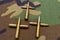 Rifle and pistol bullets gathered together in the shape of a cross. War concept. Military cloth background shot