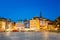 Riga Latvia. Ancient Buildings On Dome Square In Bright Evening Illumination In Summer, Blue Sky