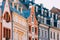 Riga Latvia. Mansard Tile Roof With Four Gable Fronted Dormer Windows On The Old Building Under Blue Sky