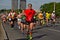 Riga, Latvia - May 19 2019: Middle aged man happily continuing marathon with both thumbs up