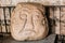 Riga, Latvia. Salaspils Stone Head Is Stone Statue Of Ancient Slavic Idol In Museum Of Dome Cathedral.