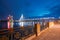 Riga Latvia. View From Deserted Embankment Of Daugava To Vansu Cable-Stayed Bridge In Bright Night Illumination From The