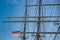 Rigging and masts of a big sailing ship in front of a blue sky with the black-red-golden flag of the state Germany, ship