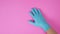 Right hand is wear latex glove or doctor glove on pink background