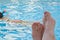 Right male foot in front of a pool with an unidentified person snorkeling