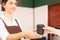 Right side of takeaway coffee cup in two hands of customer and beautiful caucasian barista woman who looks at customer, focusing