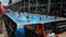 Rimini, Italy - june 2019:  Girls Doing Water Exercises with Dumbbells in Outdoor Swimming Pool with Music and Teacher on Stage