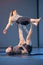 Rimini, Italy - may 2019: Couple Practicing Yoga and Fitness: Girl in Balance Position on Partnerâ€™s Legs