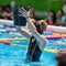Rimini, Italy - may 2019: Girl Doing Water Exercises in Outdoor Swimming Pool Emptying a Bucket of Water on her Head