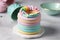 ring cake made using a stack of colorful and playful marble or pastel cake layers